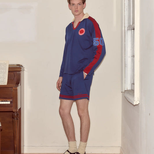 Tasoni blue long sleeve v-neck polo with red accents and '50' patch on sleeve, paired with matching shorts.