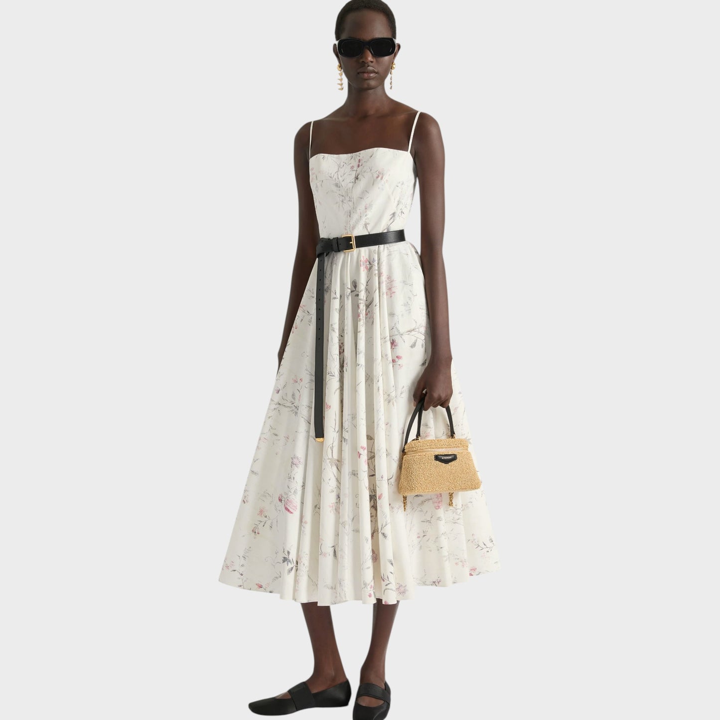 Tasoni beige Antigona Givenchy bag made of natural straw with black leather handles, worn by a model in a floral print dress.