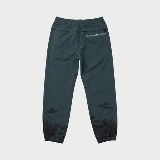 Tasoni green Undercover x VLTN elastic waist pants with grey UFO and mountain print. Features drawstring waist and cuffed ankles.