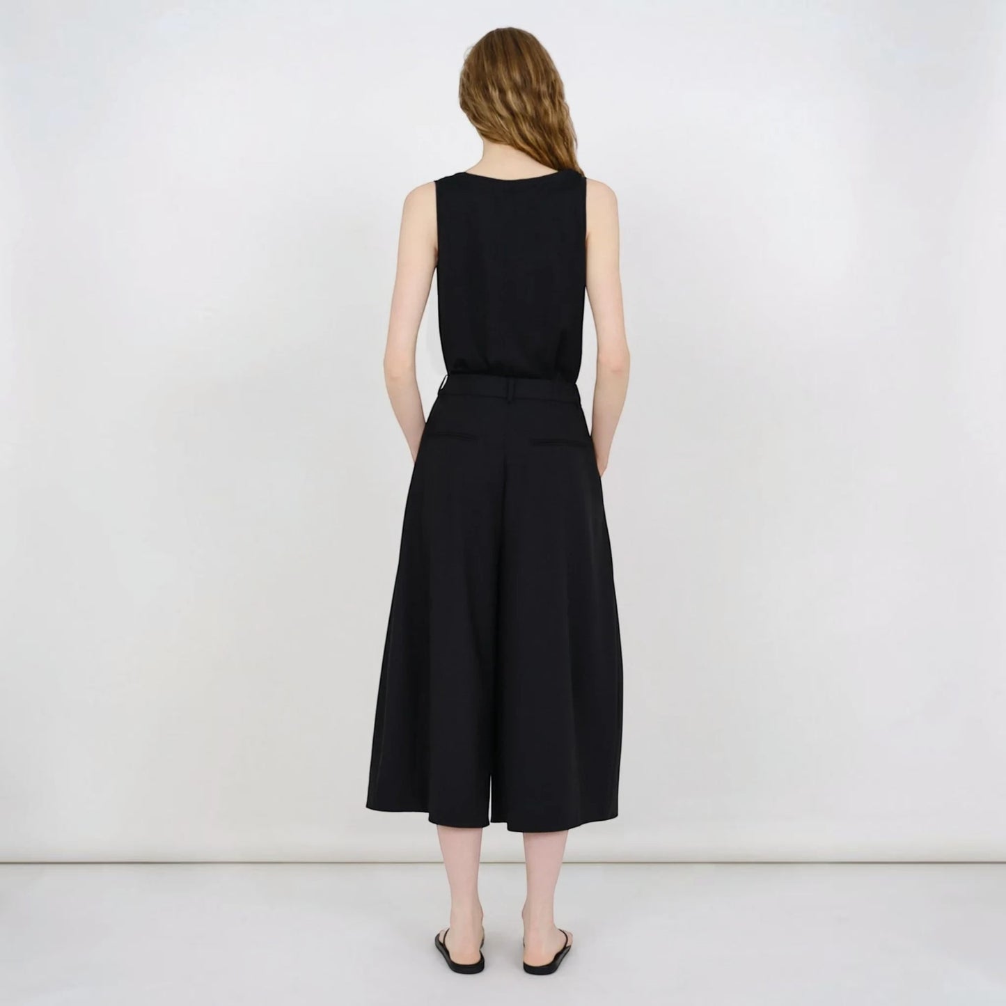 Tasoni Partow Ida black virgin wool wide-leg trousers worn by a model from the back view.