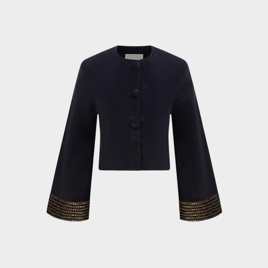 Tasoni Destree black velvet jacket with structured shoulders and intricate gold lace detailing on the flared sleeves.