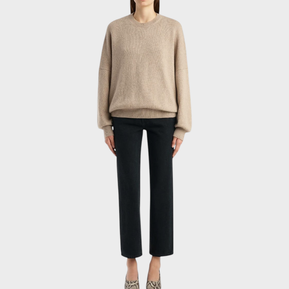 Tasoni Khaite Margaux putty cashmere sweater with a relaxed fit, crewneck, and ribbed trim worn with black jeans.