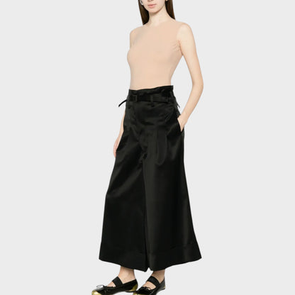 Tasoni beige crew neck sleeveless bodysuit in almond, paired with black wide-leg trousers and black and gold ballet flats.