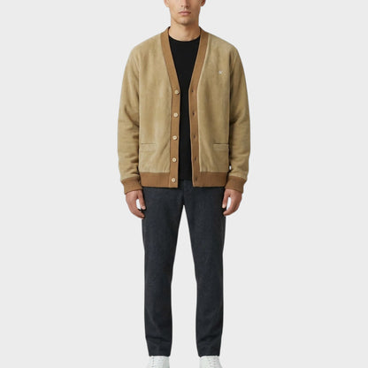 Tasoni beige suede and wool blend cardigan with brown trim and ribbed cuffs. Model wears black t-shirt and charcoal trousers.