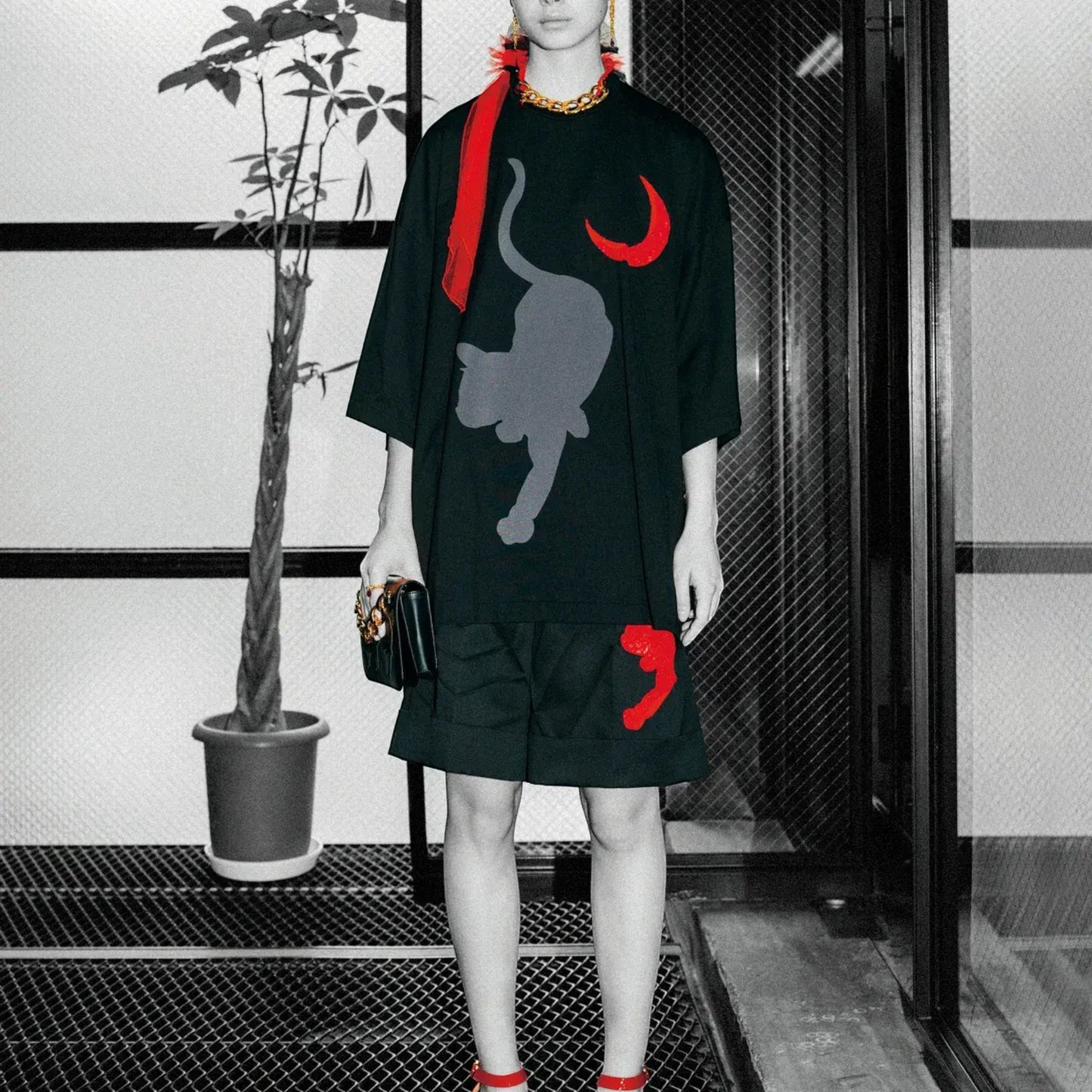 Tasoni black cotton t-shirt with grey cat and red moon embroidery, short sleeves, crew neck. Model wears red sunglasses and scarf.