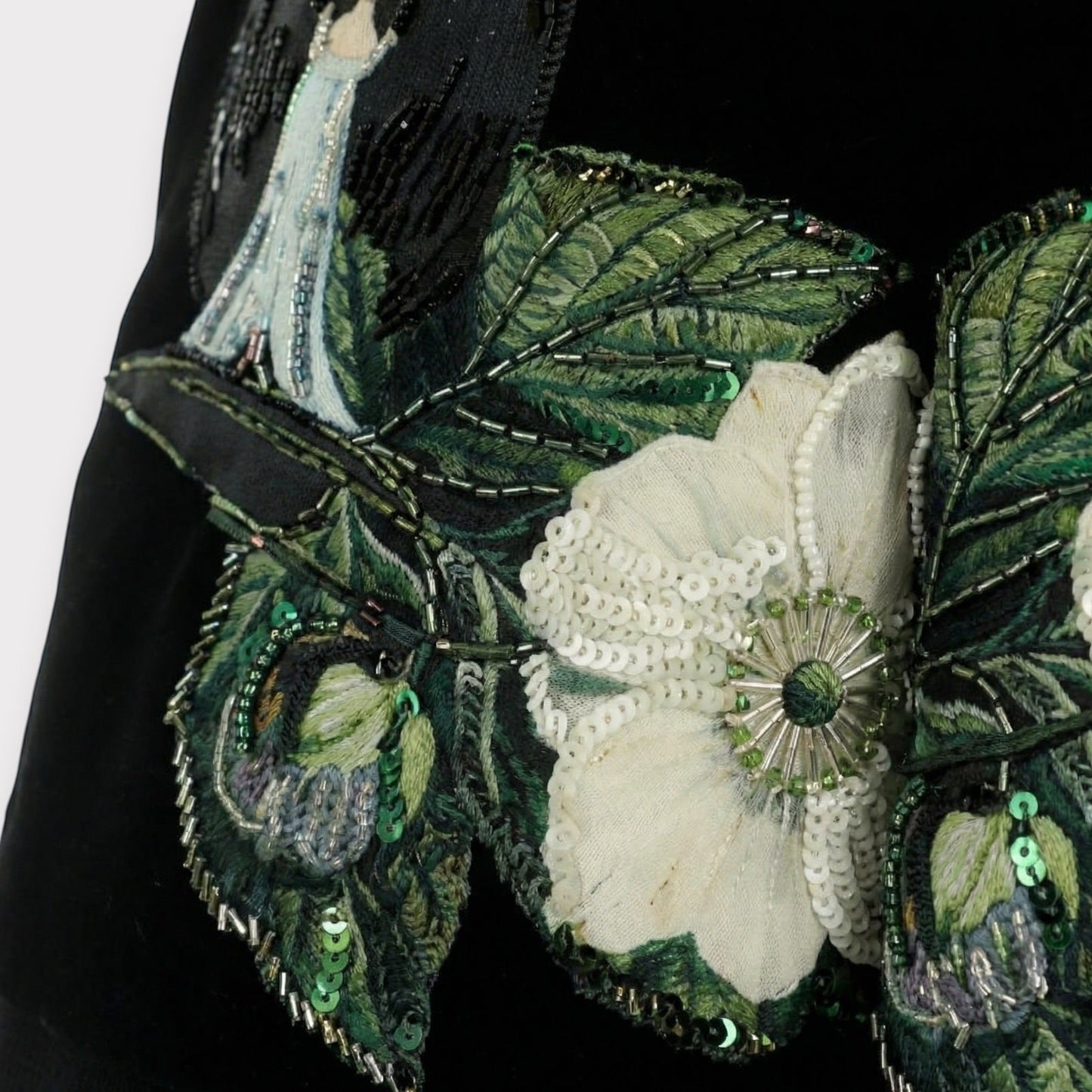 Tasoni black velvet shorts with embroidered floral patches, sequins, and beadwork. Features a high waist and pleated front.