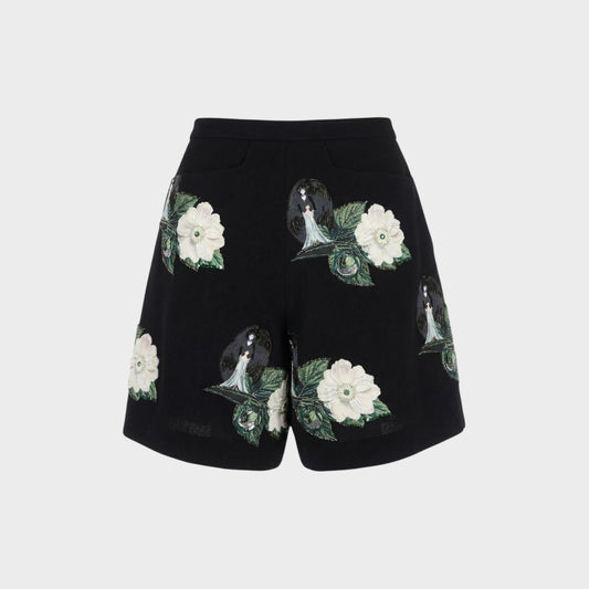 Tasoni black high-waist shorts with embroidered floral and figure patches. Features front pleats and a relaxed fit.