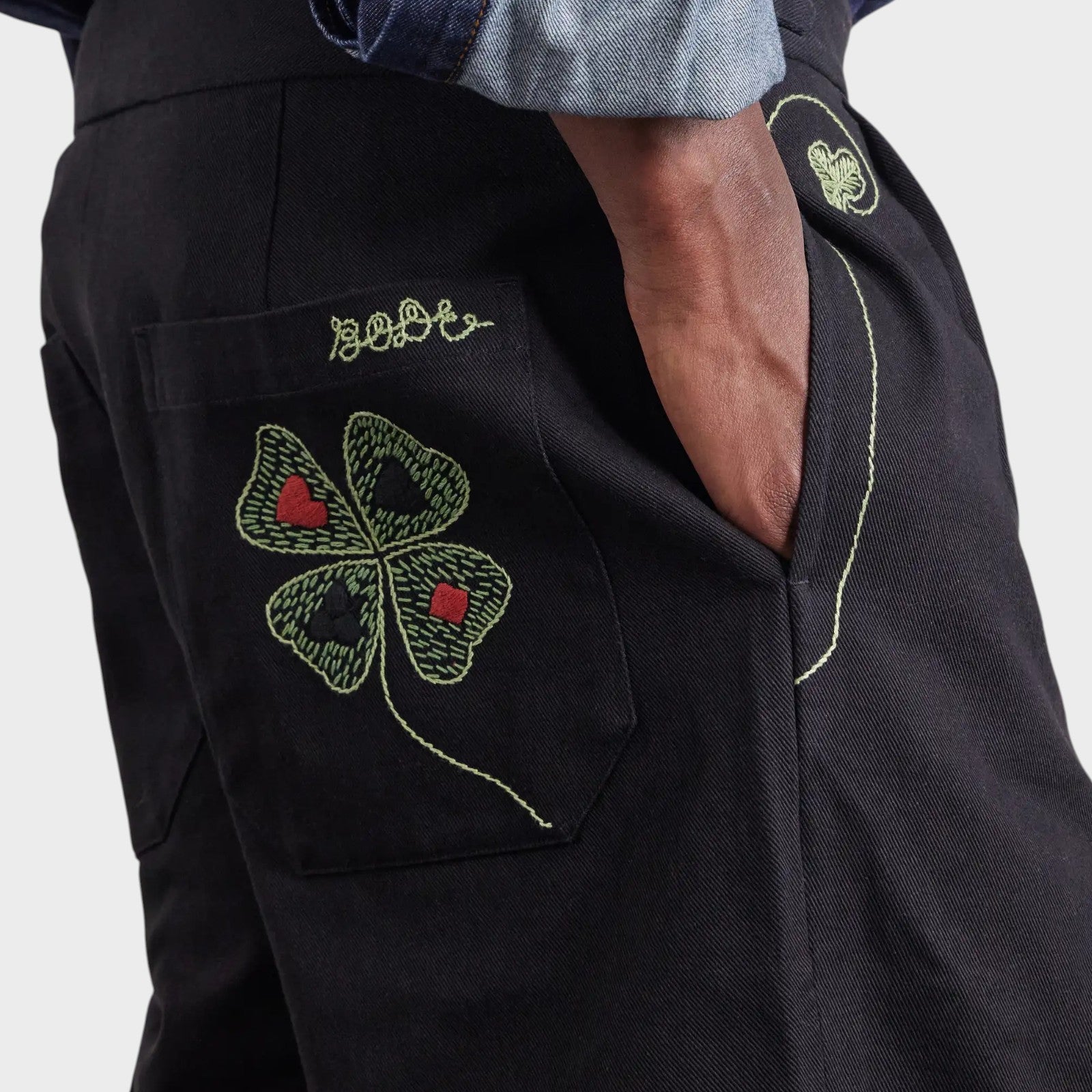 Tasoni black mid-rise trousers with embroidered lucky clover motif and playing card details.