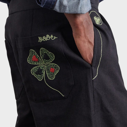 Tasoni black mid-rise trousers with embroidered lucky clover motif and playing card details.