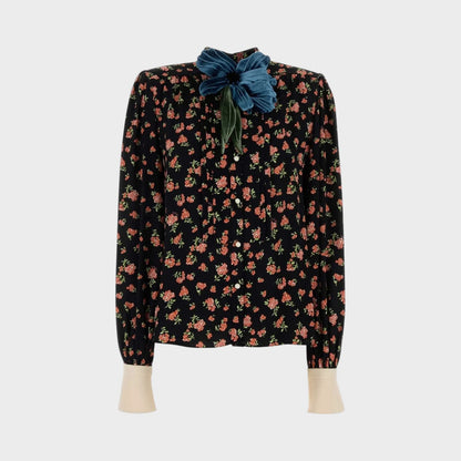 Tasoni black long-sleeve shirt with multicolor floral print and a large teal velvet flower accent at the collar.