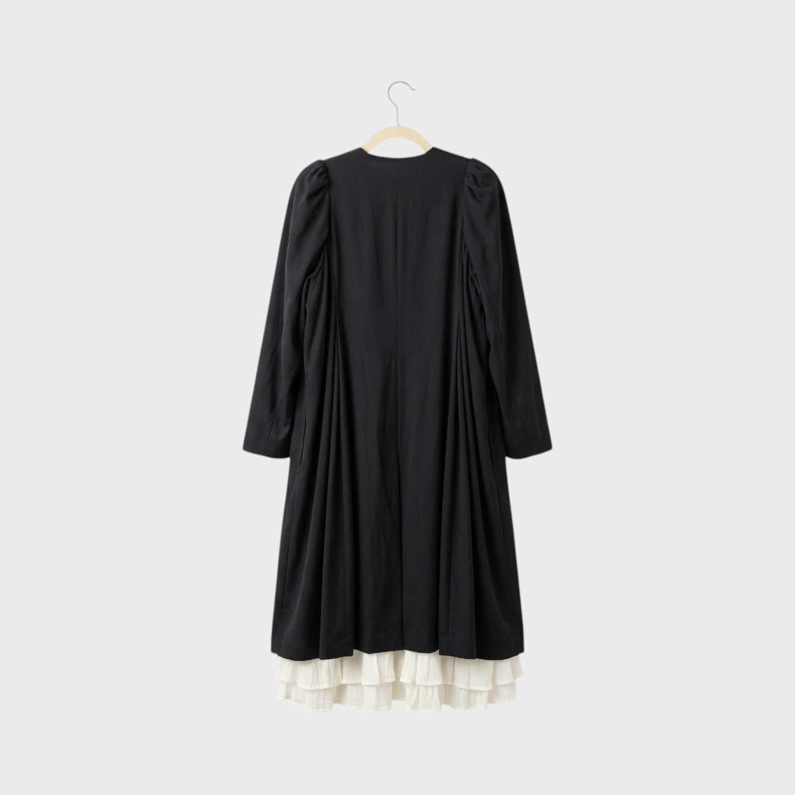 Tasoni black long coat with white ruffled lining and puff sleeves, back view.