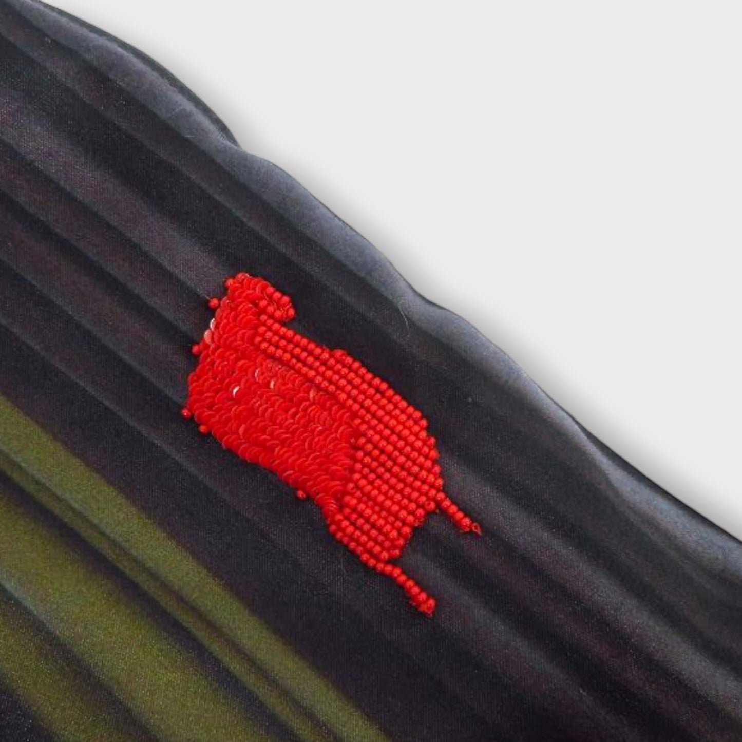 Tasoni black silk sweatpants with a green print and a red sequin and bead embellishment.