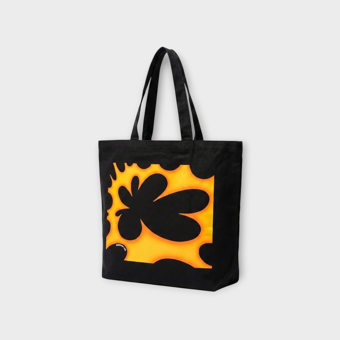 Tasoni black canvas tote bag with a bold orange and black abstract floral print.