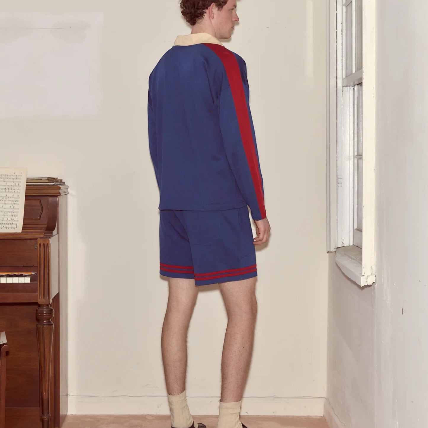 Tasoni blue long sleeve polo shirt with red stripe detail and cream collar, paired with matching blue shorts.