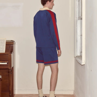 Tasoni blue long sleeve polo shirt with red stripe detail and cream collar, paired with matching blue shorts.