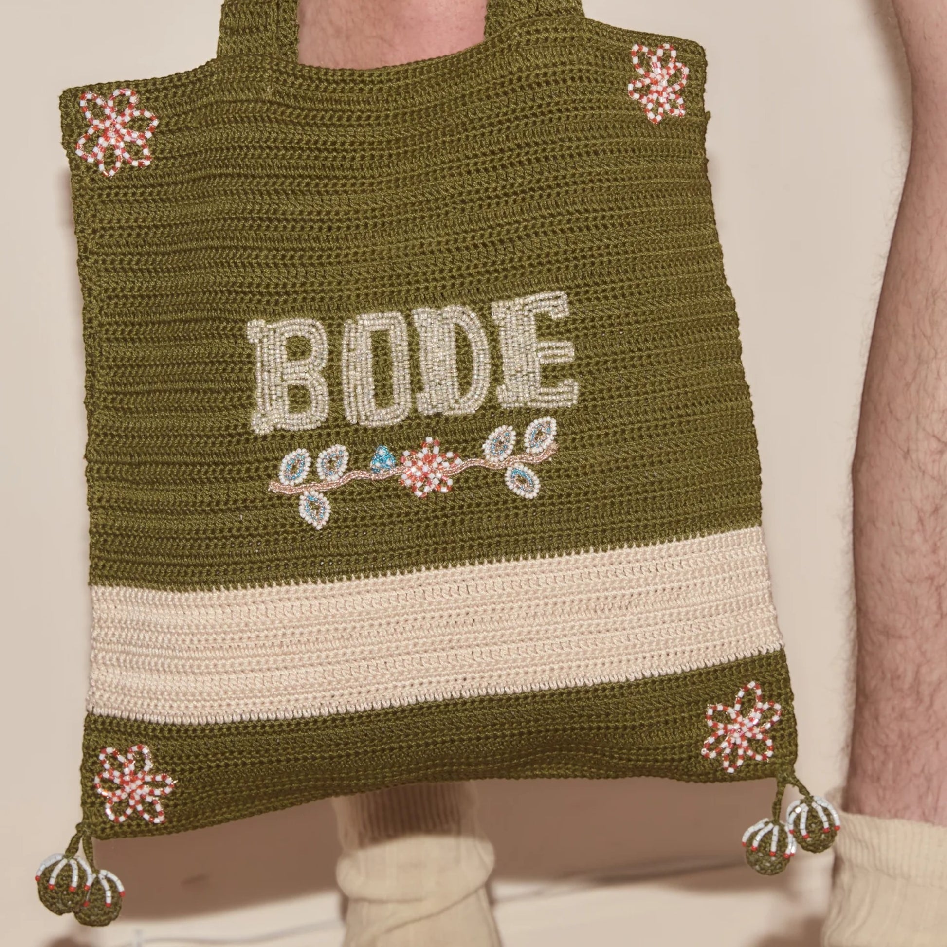 Tasoni Bode Marsh crochet tote bag in green yarn with beaded floral details and "BODE" lettering.