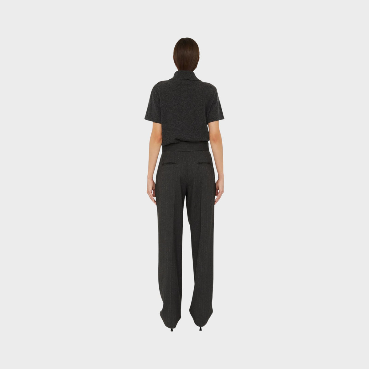 Tasoni Christopher Esber charcoal grey cashmere short sleeve polo shirt worn with pinstriped trousers, back view.