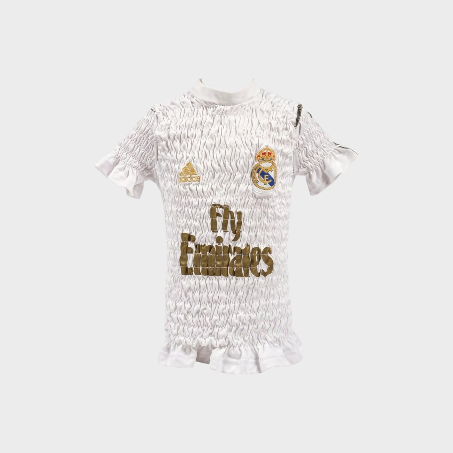 Tasoni Conner Ives white reconstituted shirred football jersey with gold logo and ruffled hem details.