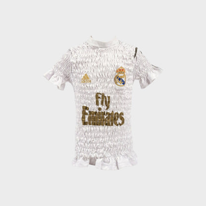 Tasoni Conner Ives white reconstituted shirred football jersey with gold logo and ruffled hem details.