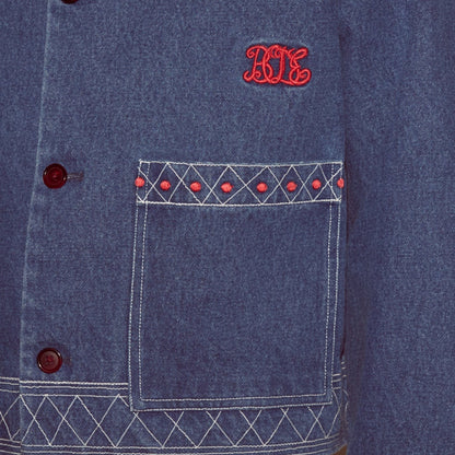 Tasoni blue embroidered denim jacket with red geometric pattern detail on pocket and red buttons.