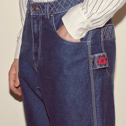 Tasoni indigo denim pants with white contrast stitching and embroidered logo detail on pocket.