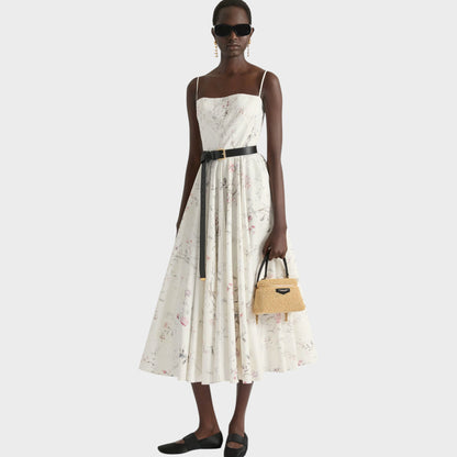 Tasoni beige Antigona Givenchy bag made of natural straw with black leather handles, worn by a model in a floral print dress.