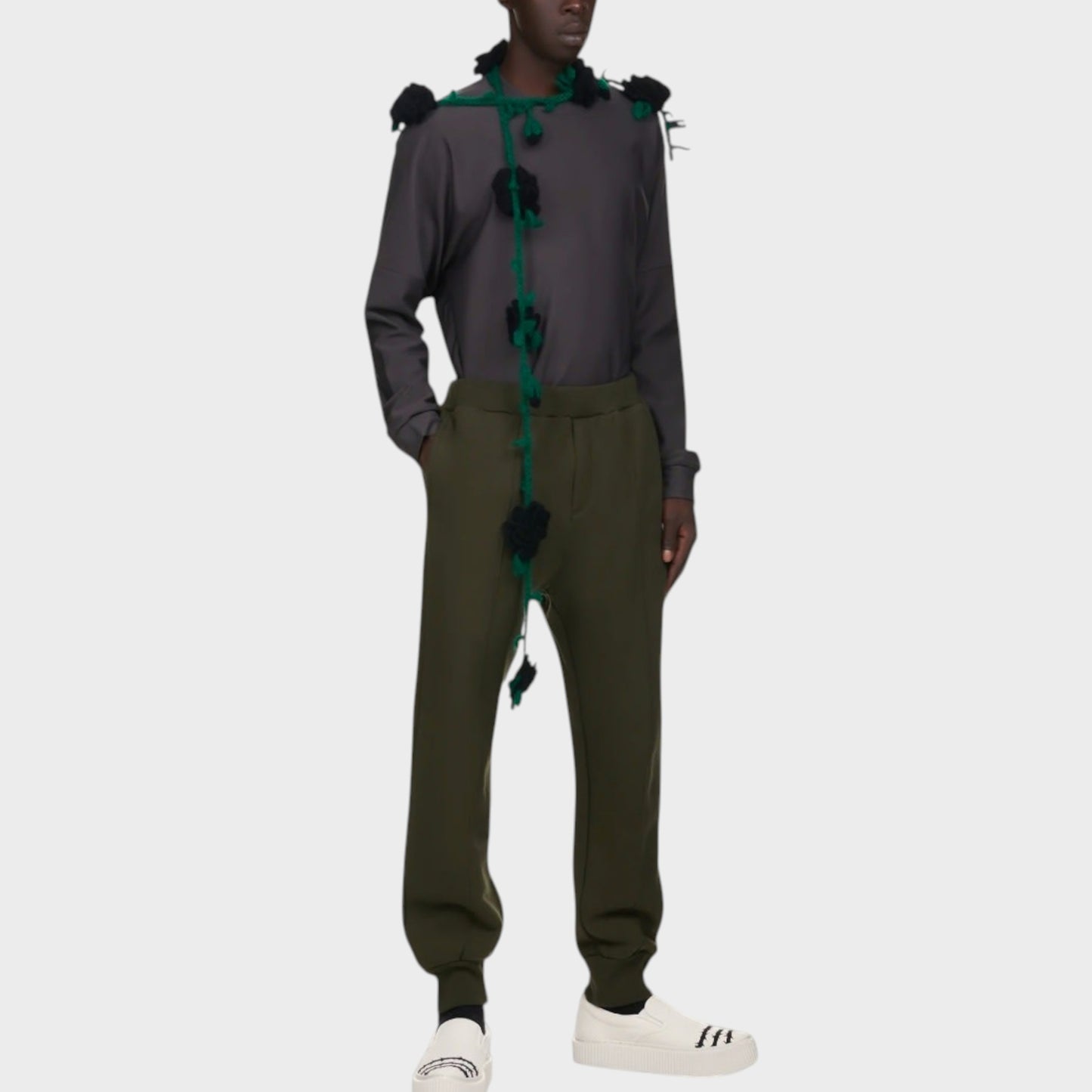 Tasoni men's dark green cotton sweatpants with elastic waist and drawstring. Model wears them with a grey long-sleeve shirt and white sneakers.