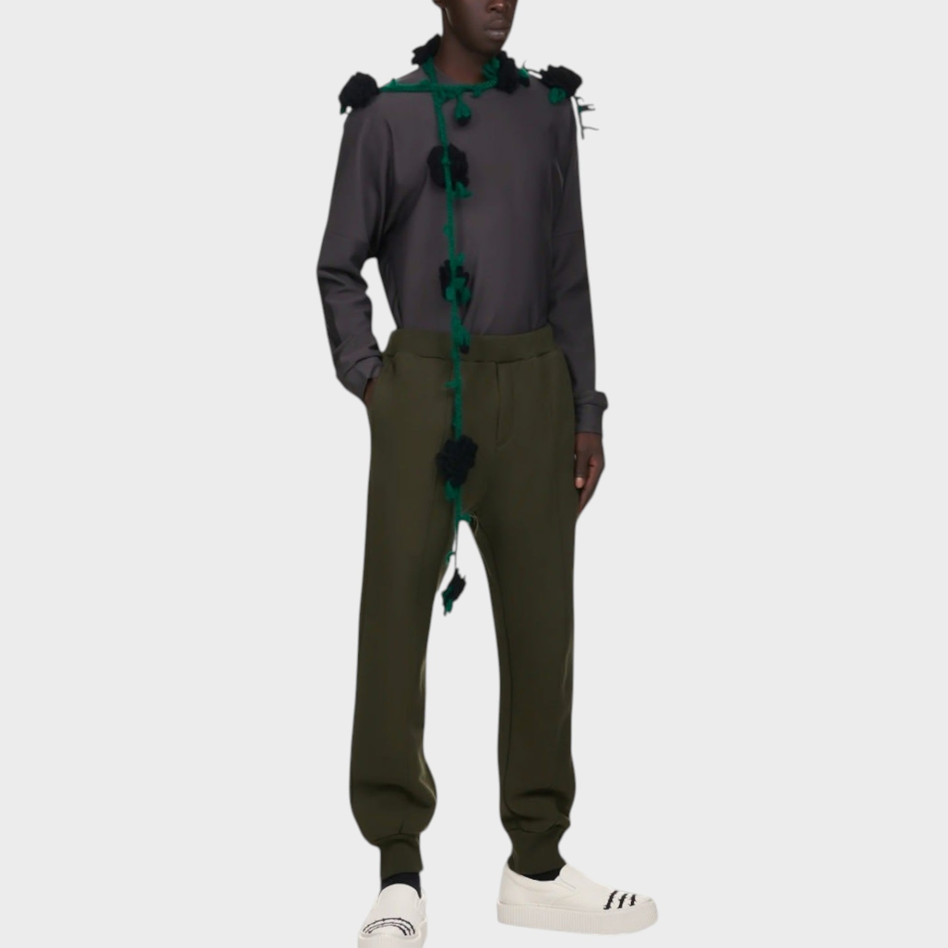Tasoni men's dark green cotton sweatpants with elastic waist and drawstring. Model wears them with a grey long-sleeve shirt and white sneakers.