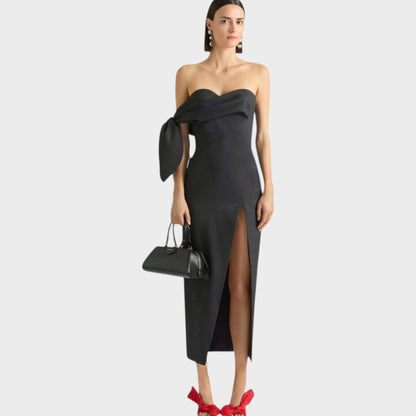 Tasoni Grey wool bustier long dress with bow detail and high slit. Model wears statement earrings and carries a black handbag.