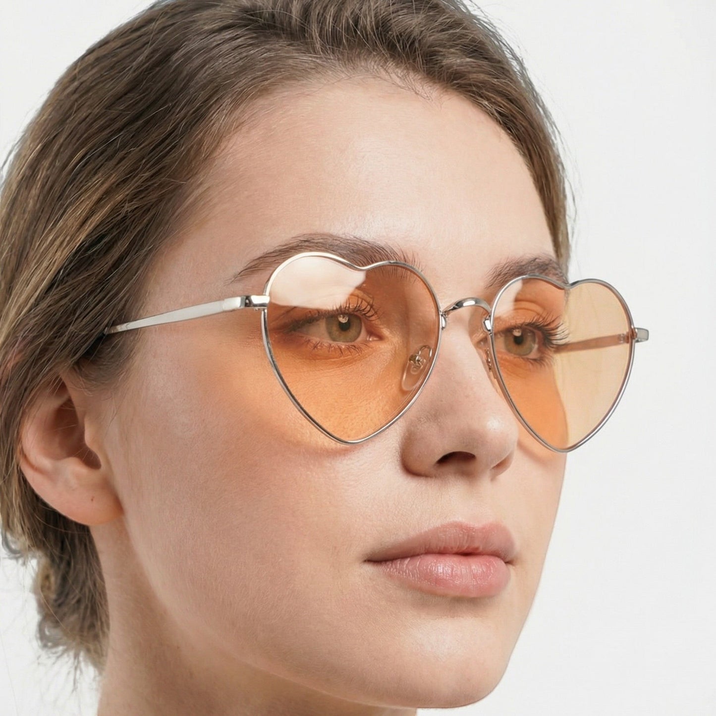 Tasoni Undercover heart-shaped sunglasses with orange lenses and silver metal frames.