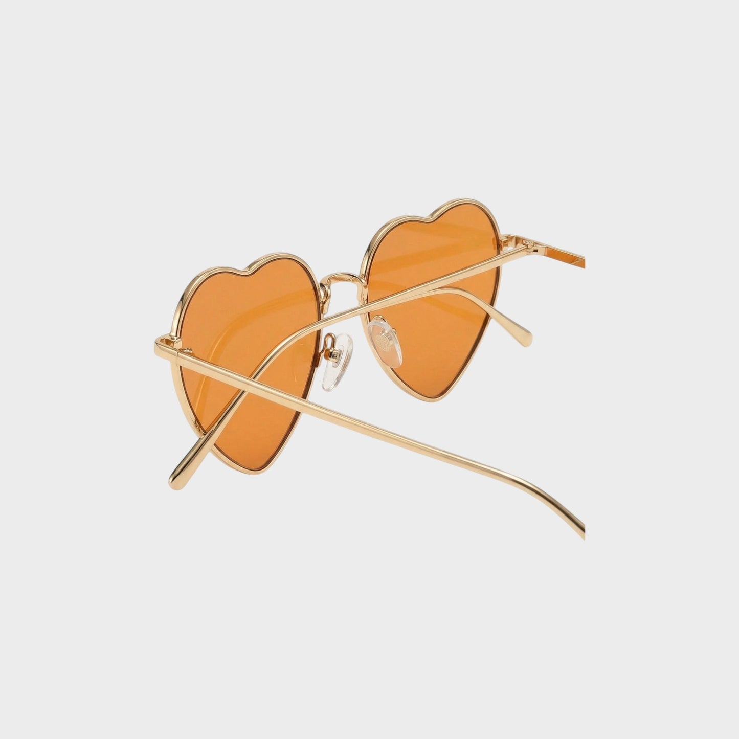 Tasoni gold-rimmed heart-shaped sunglasses with orange lenses and adjustable nose pads.