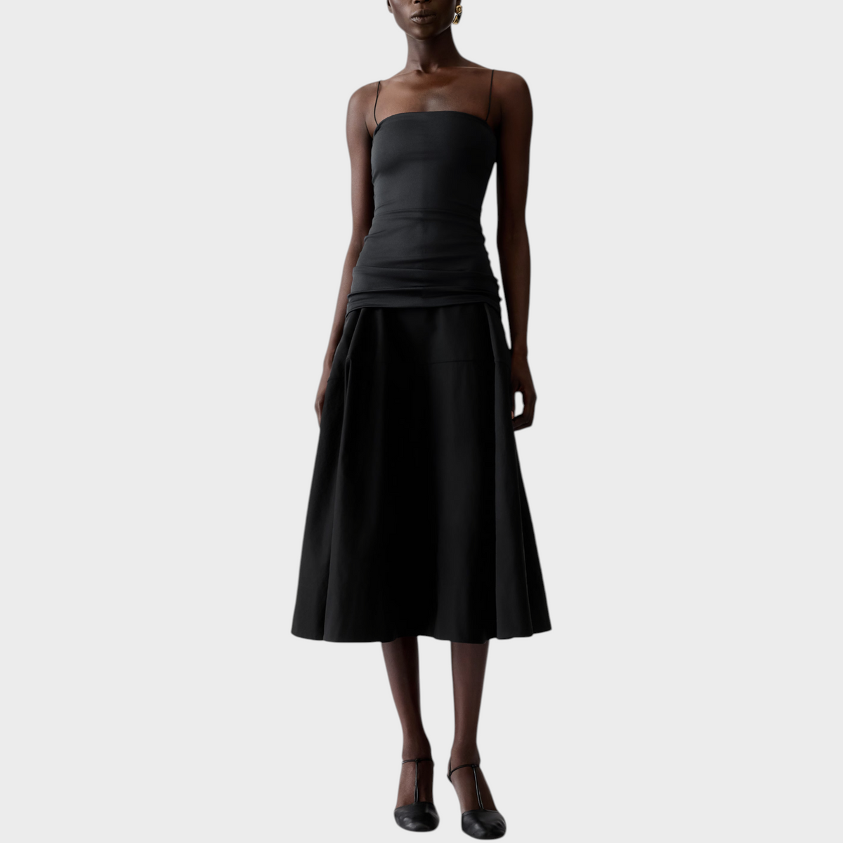 Tasoni model wearing a black Jacquemus La Robe Paradiso midi dress with thin straps and a flared skirt