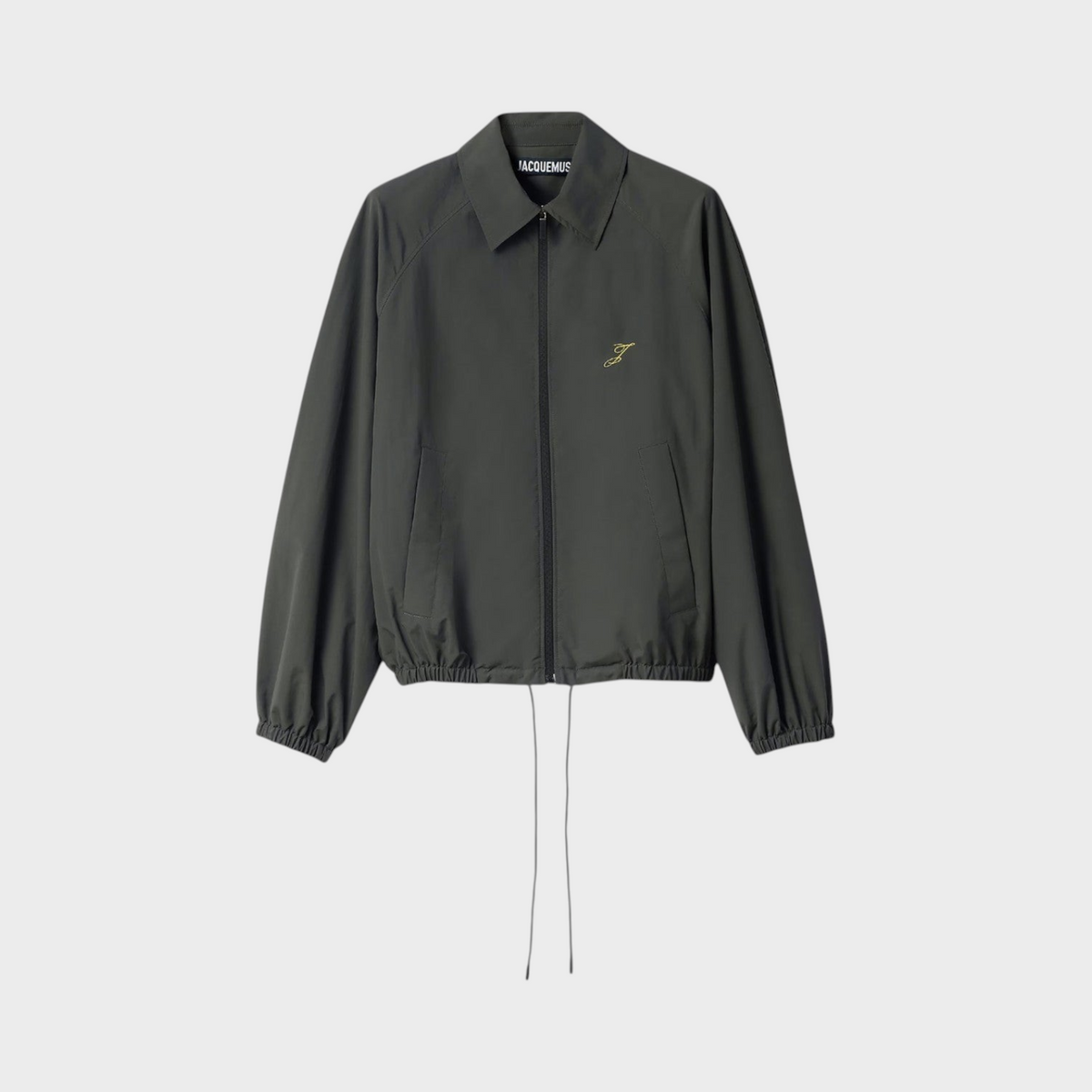 Tasoni Jacquemus Le Coupe-Vent dark grey windbreaker jacket with a classic collar, zip front, and gold logo detail.