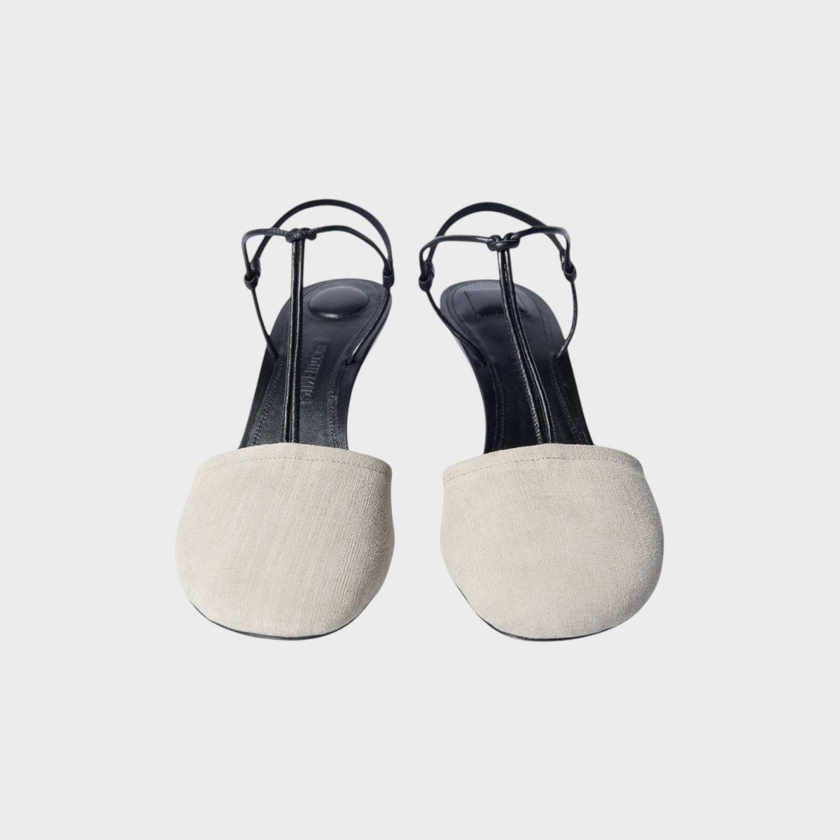 Tasoni Jacquemus Les Sandales Pina strap heels featuring a beige fabric rounded toe and black leather ankle straps.