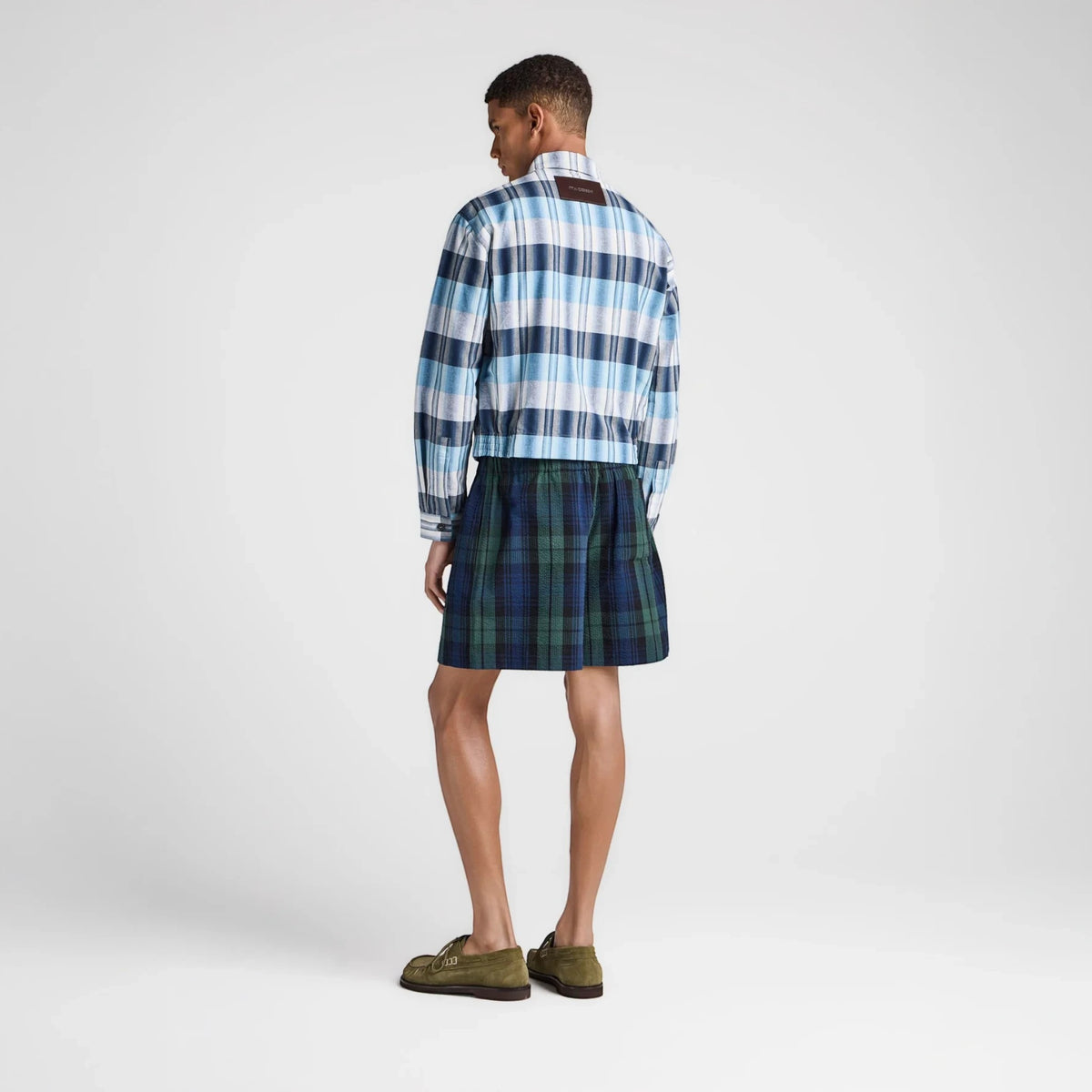 Model wearing Tasoni JW Anderson green and blue plaid check shorts with an elastic waistband from the back view.