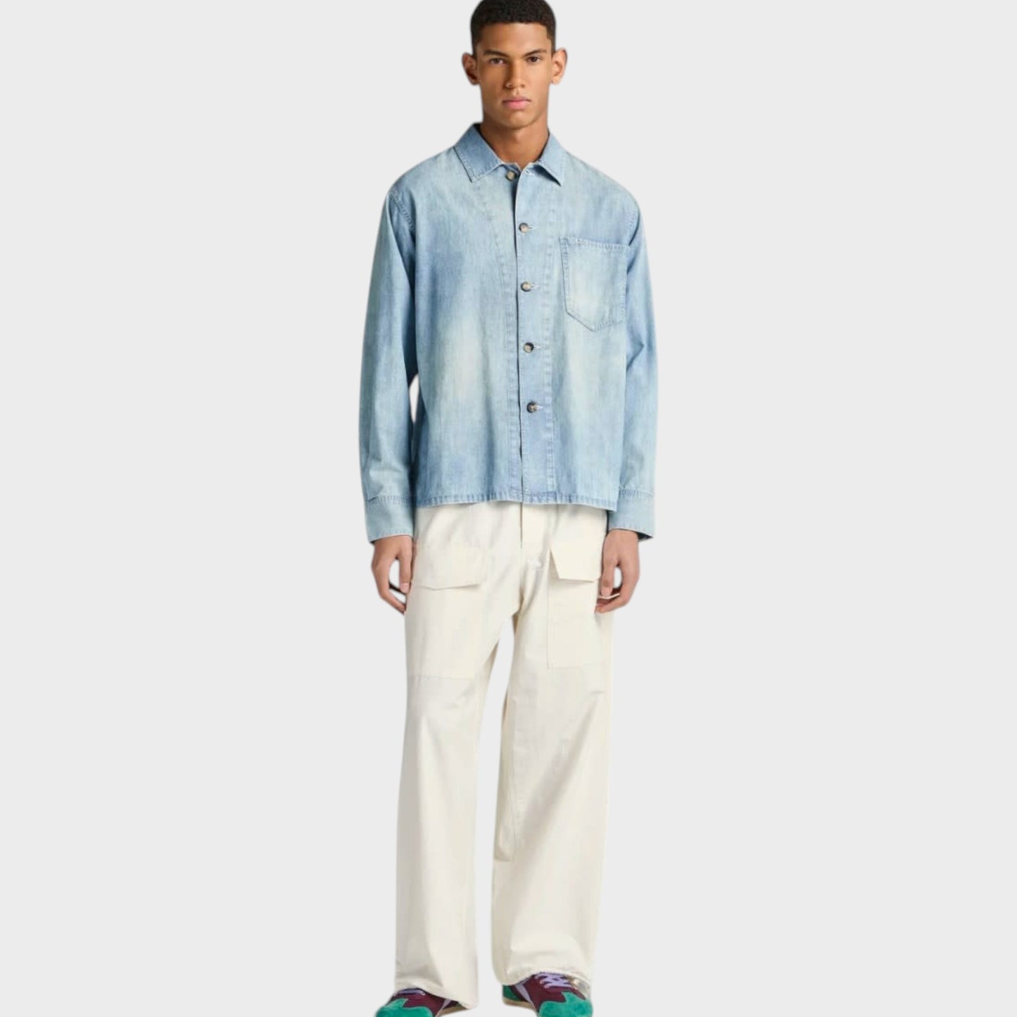 Model wearing a pale blue J.W.Anderson cotton denim shirt with a slant pocket, styled by Tasoni.