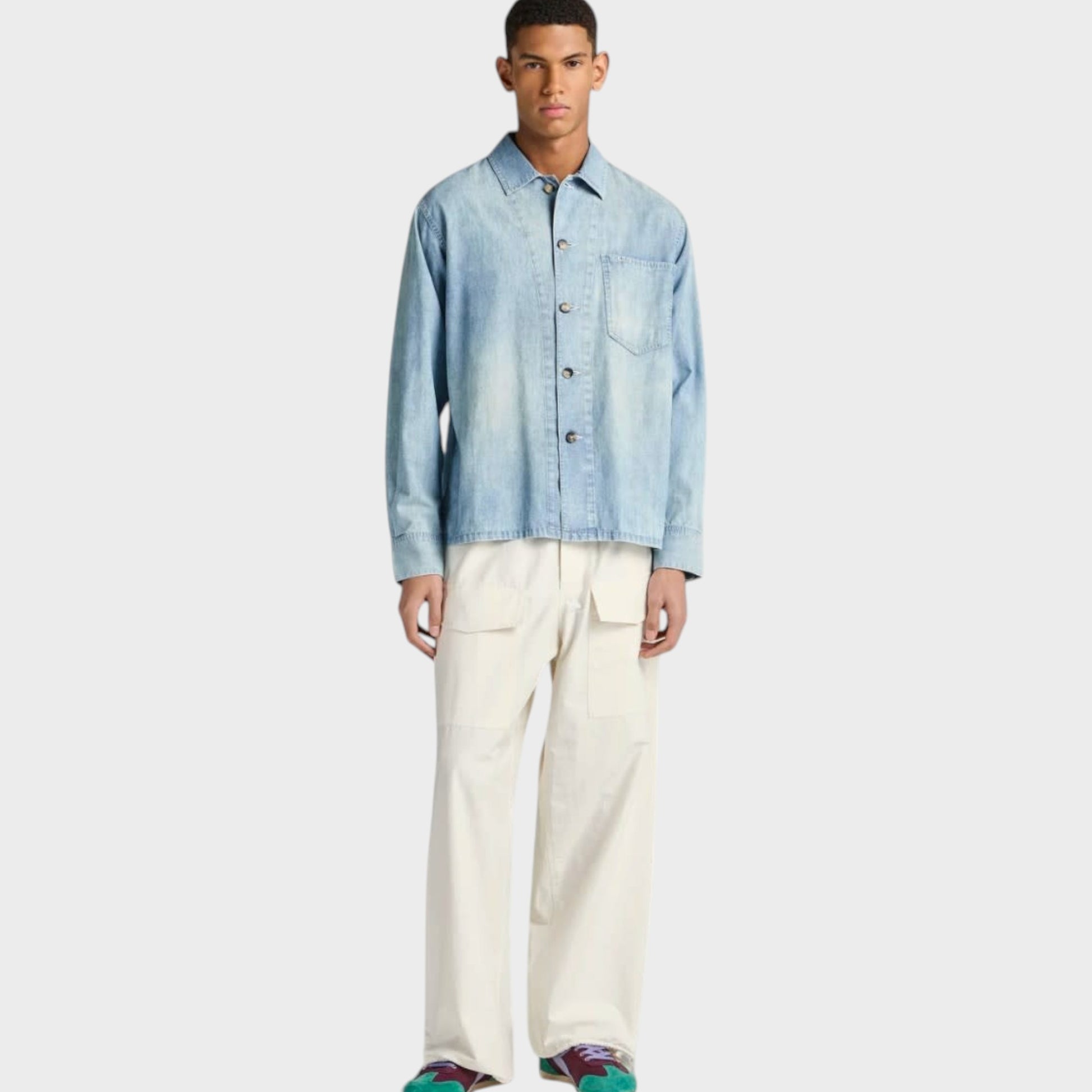 Model wearing a pale blue J.W.Anderson cotton denim shirt with a slant pocket, styled by Tasoni.