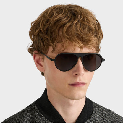 Tasoni model wearing black JW Anderson Jwa05 titanium aviator sunglasses with a sleek, modern design.