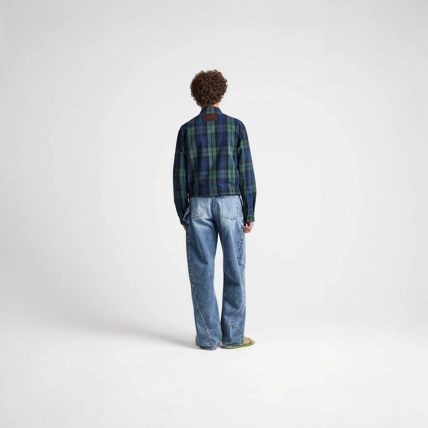 Model wearing Tasoni J.W.Anderson navy and green cotton check print collared zip jacket with blue jeans from behind.