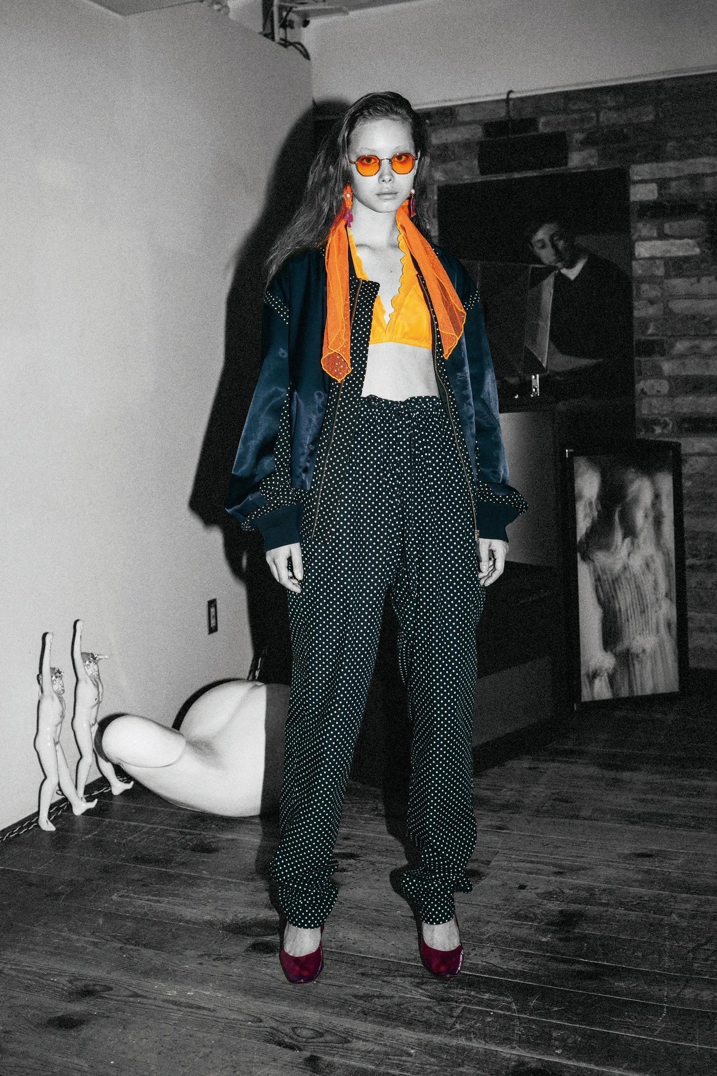 Tasoni navy satin zip-up bomber jacket with polka dot detailing, worn by a model with orange scarf and sunglasses.