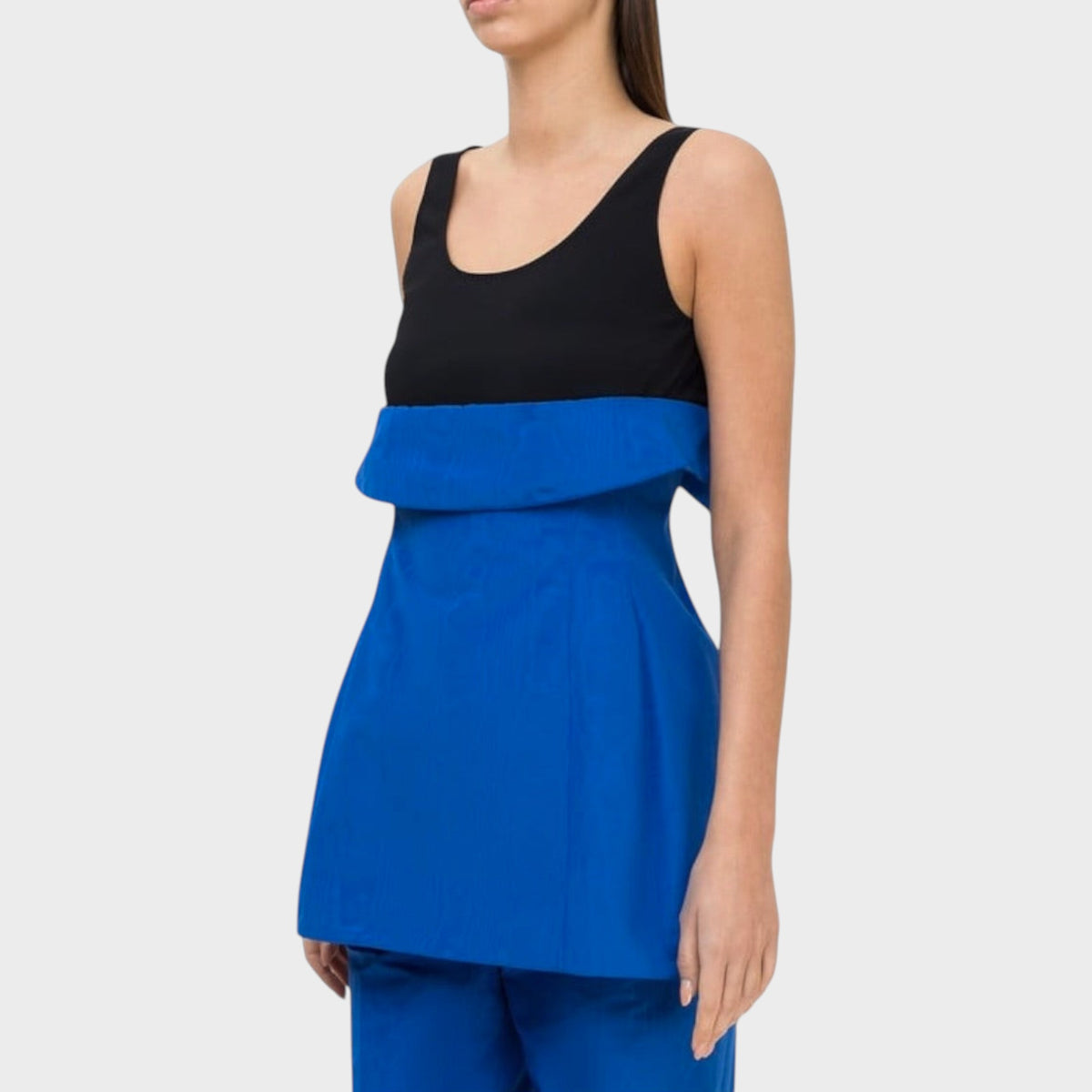Tasoni Nina Ricci cotton tank top featuring a black scoop neck bodice and a vibrant blue peplum waist detail.