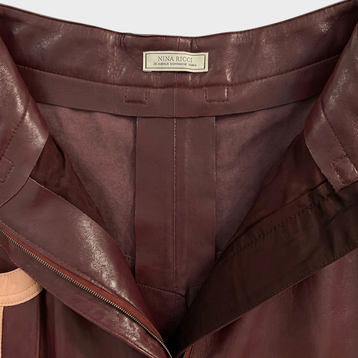 Tasoni Nina Ricci burgundy leather skirt featuring a visible brand label and front zipper detail.