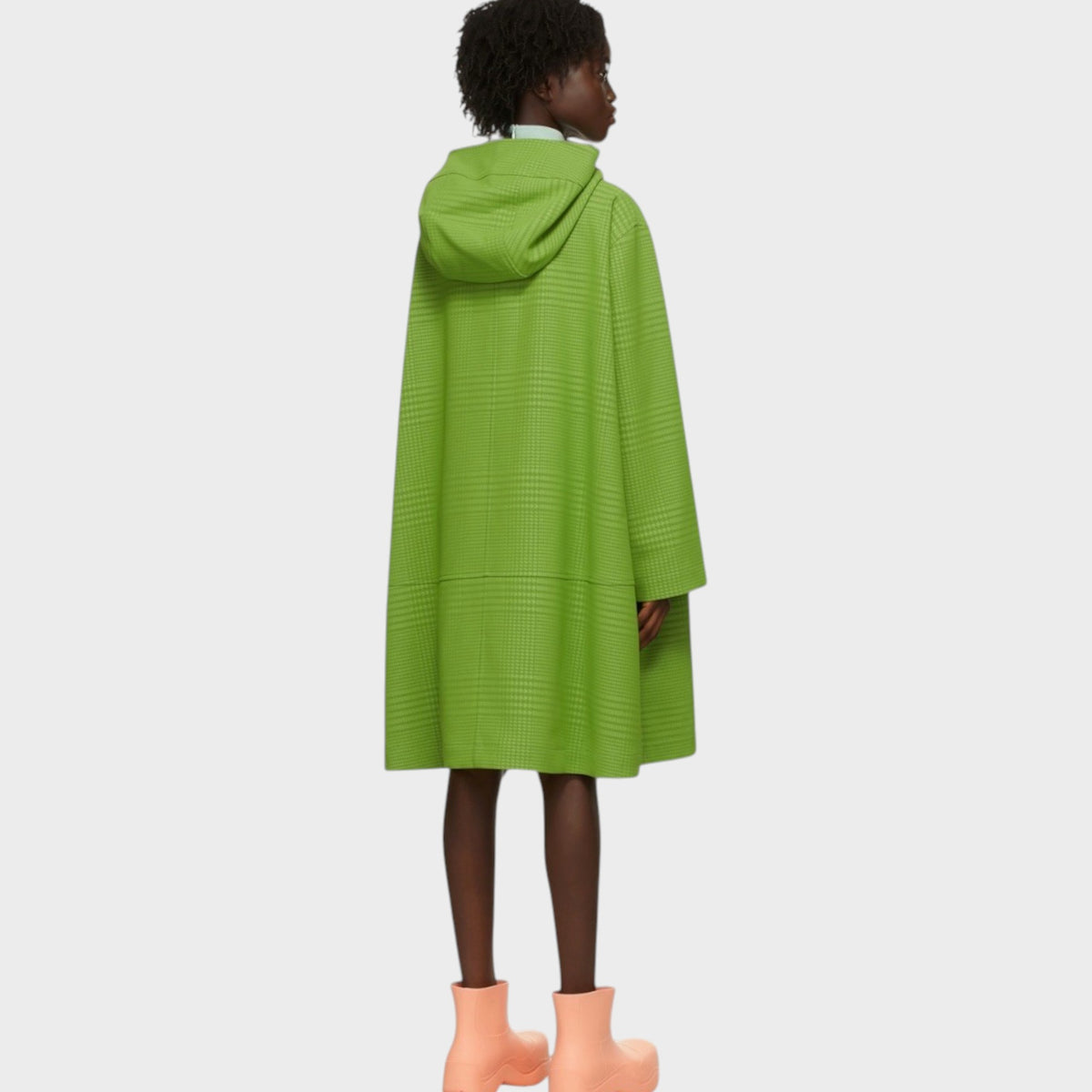 Model wearing a Tasoni Nina Ricci lime green houndstooth jacquard hooded jacket with a loose, flared silhouette.