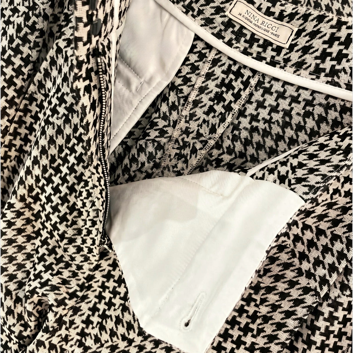 Tasoni Nina Ricci wool trousers featuring a classic black and white houndstooth pattern and interior white lining.