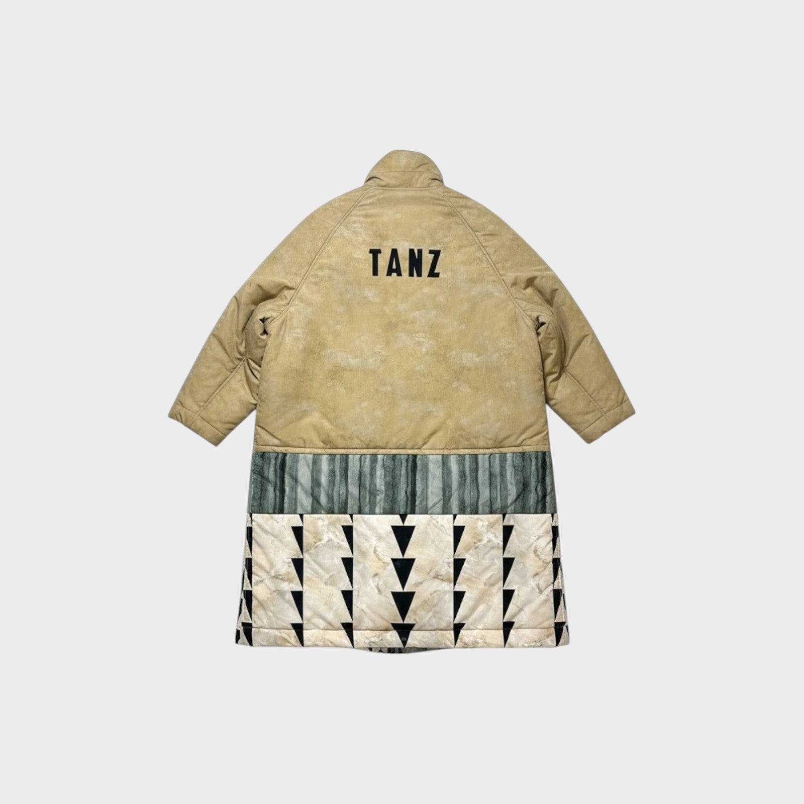 Tasoni beige oversized padded coat with 'TANZ' print on back, featuring green striped and marble print panels with black triangles.
