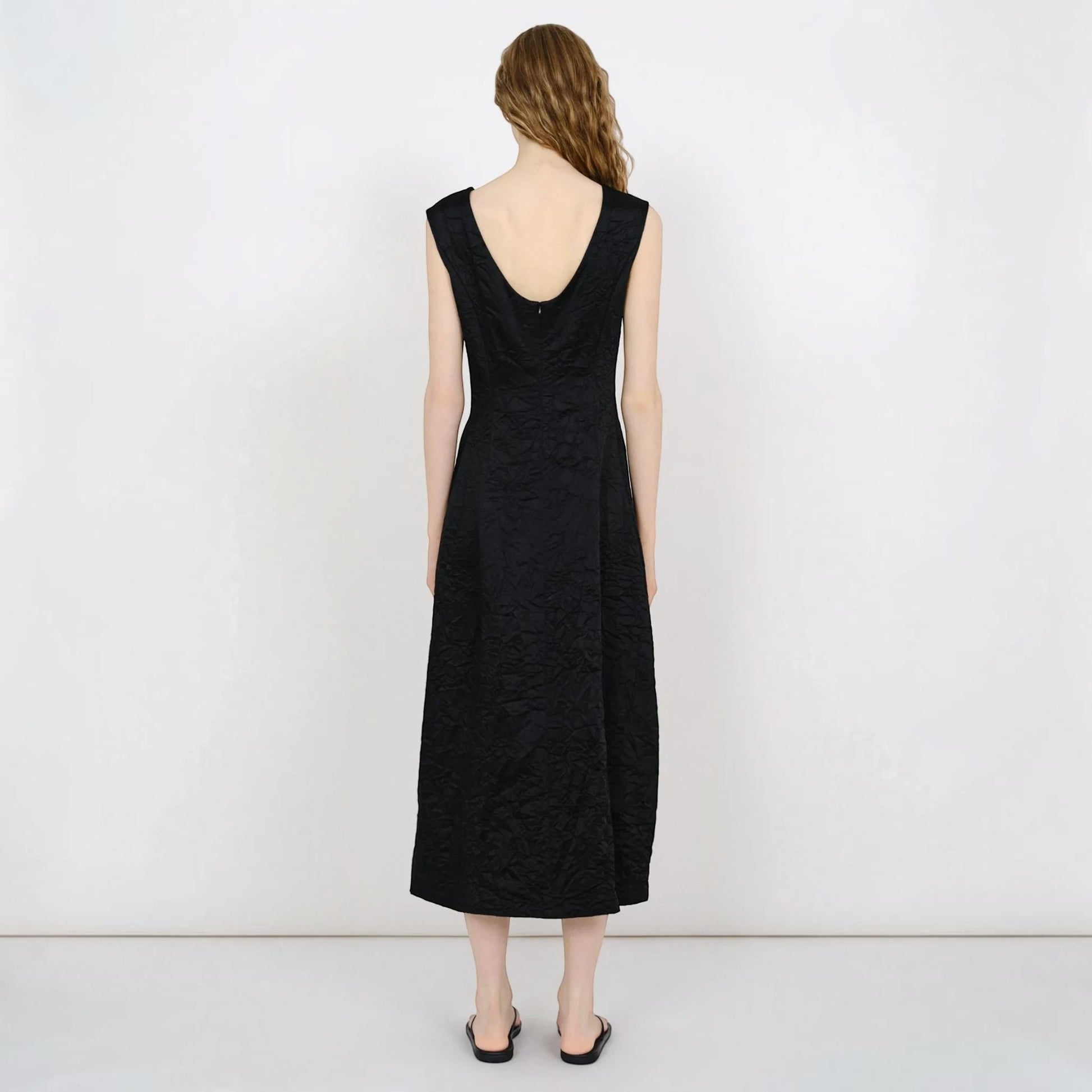 Model wearing a black Tasoni Partow Koda cotton blend midi dress with a scoop back and textured fabric finish.