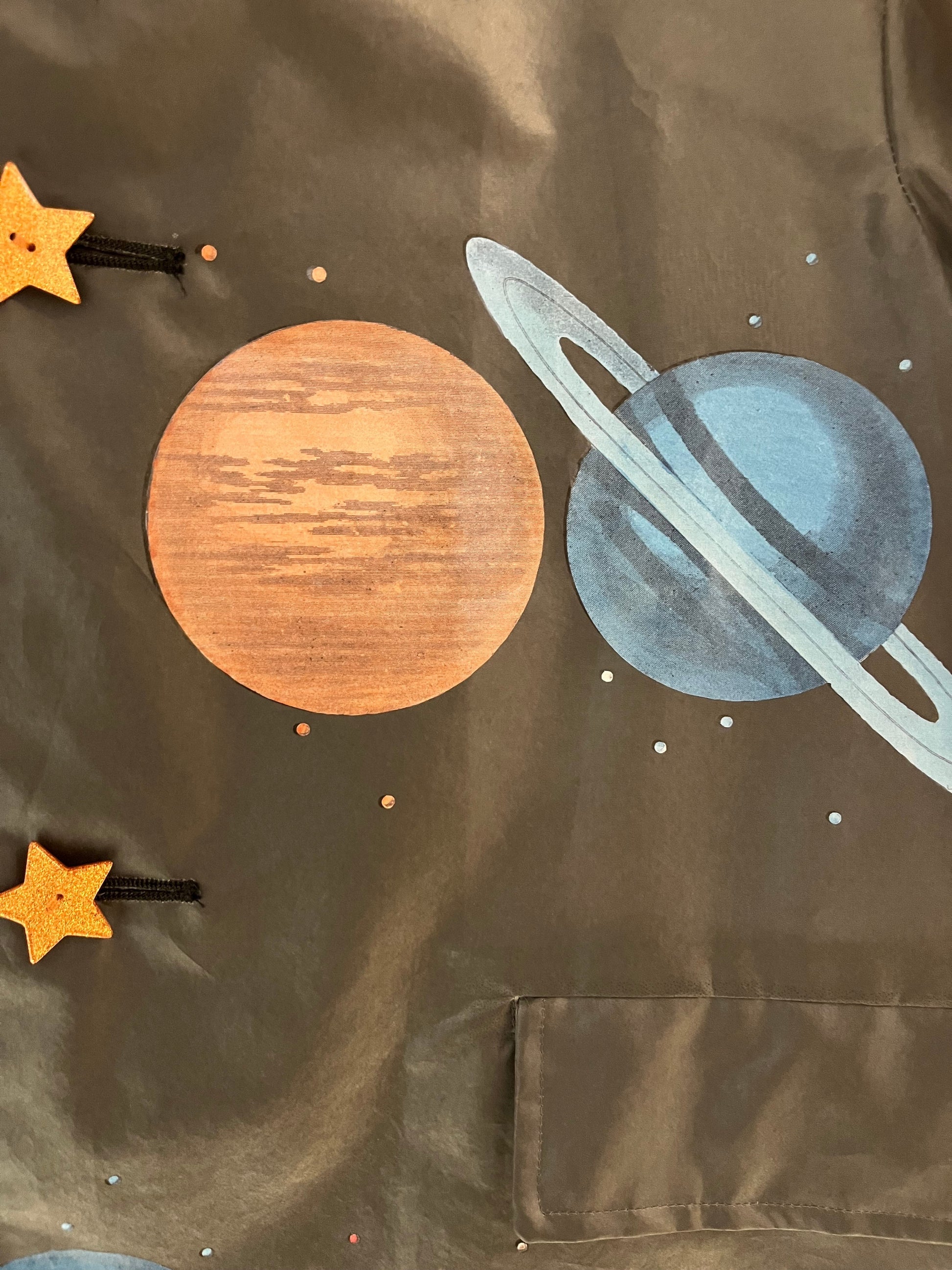 Tasoni sheer coat with a fun planets and stars print. Features a pocket and button details.