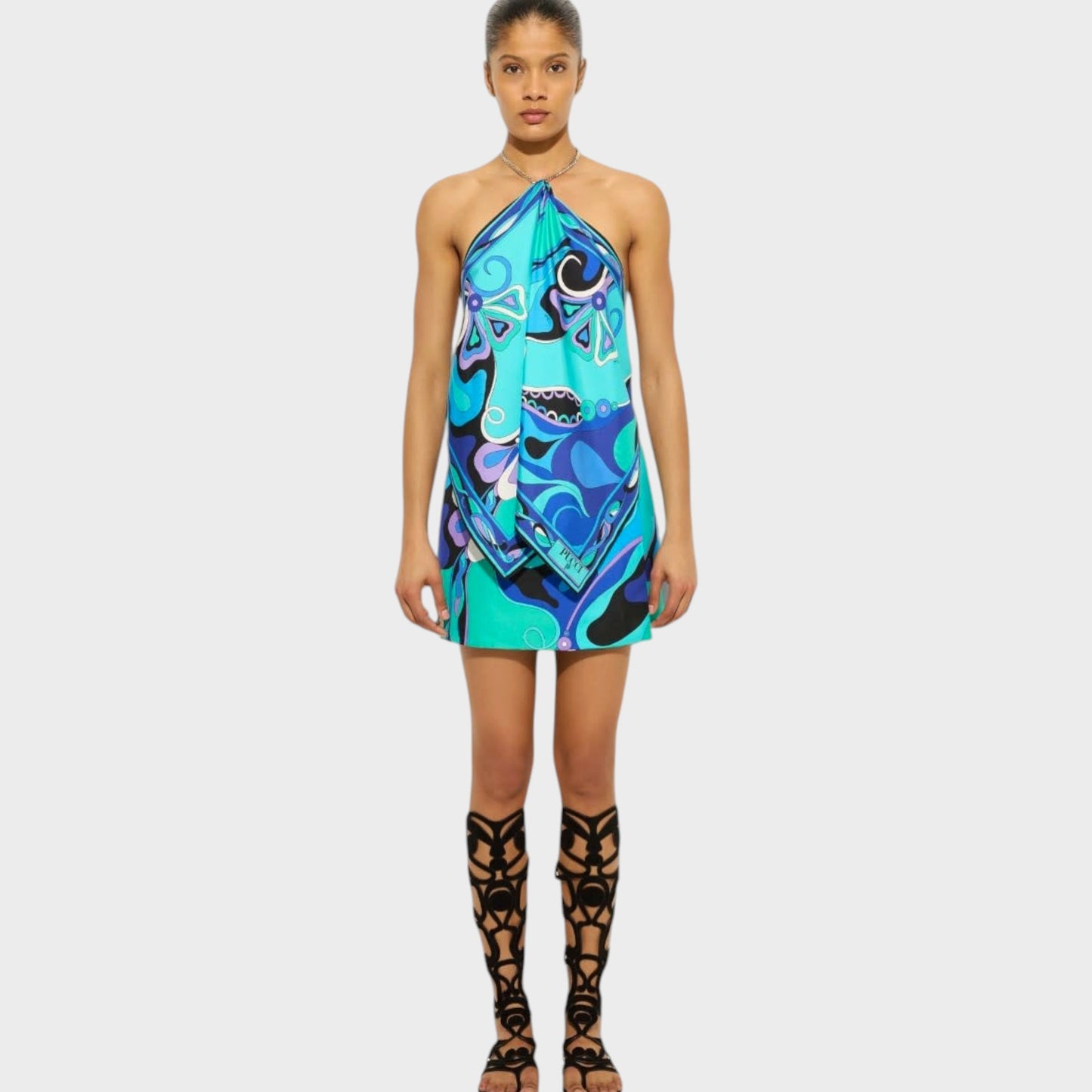 Model wearing a Tasoni Pucci silk chain halter top in turquoise blue with an Orchidee print and metal chain detail.