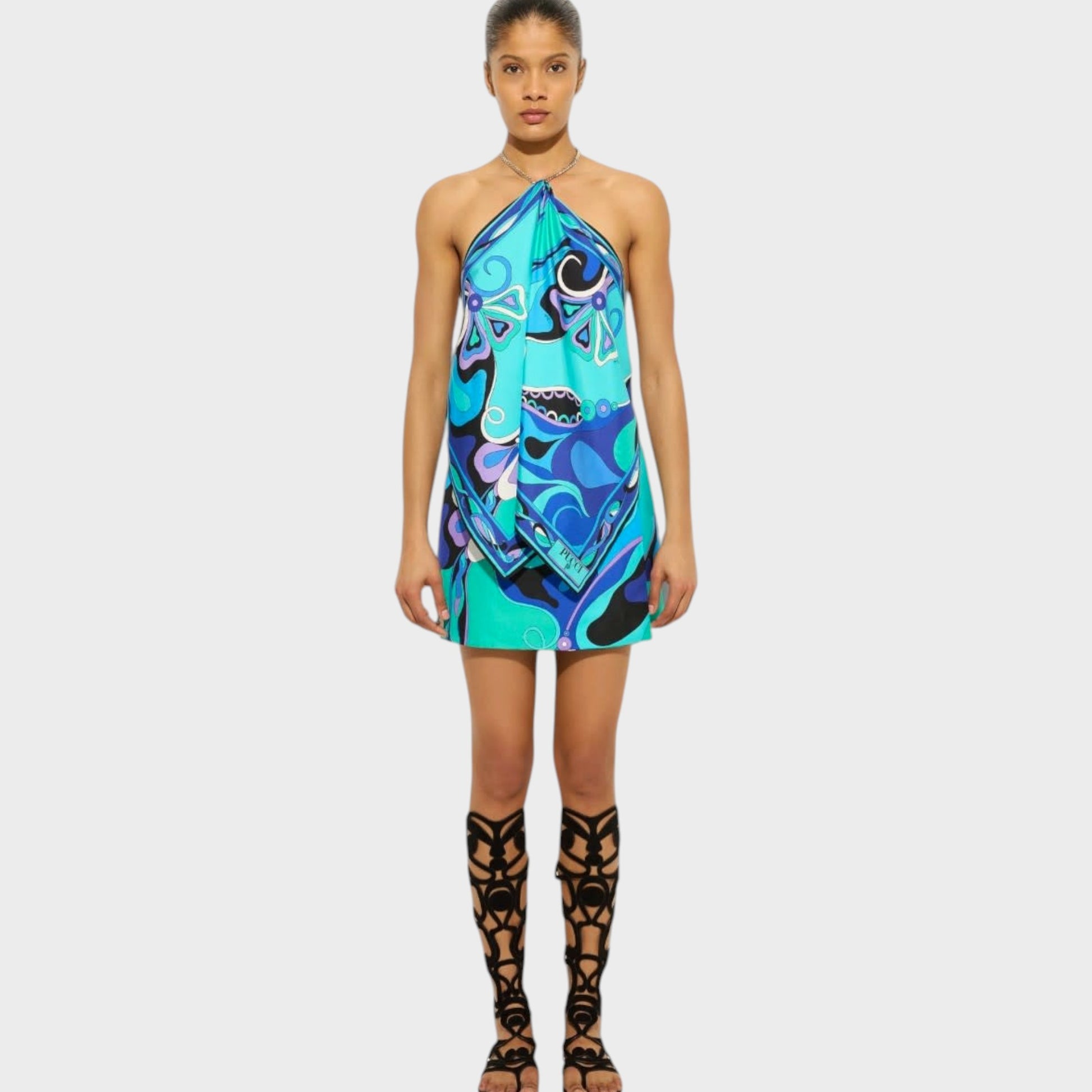 Model wearing a Tasoni Pucci silk chain halter top in turquoise blue with an Orchidee print and metal chain detail.