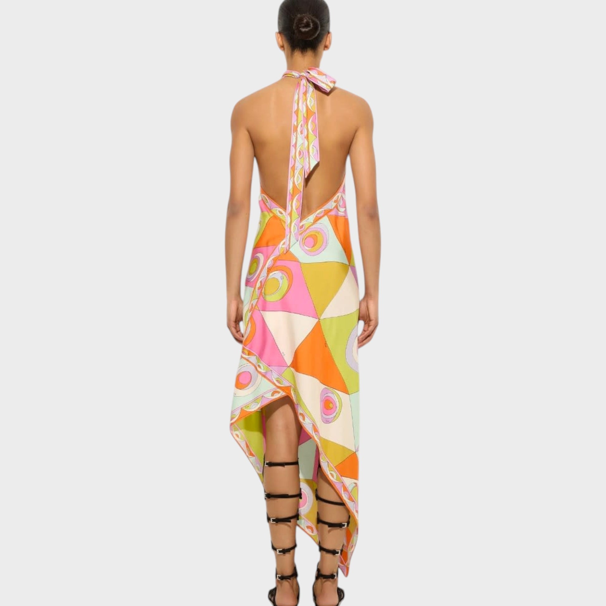 Tasoni Pucci silk halter neck dress with vibrant geometric print, open back, and asymmetrical hem on a model.
